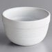 An Acopa Capri coconut white stoneware bouillon bowl with a curved edge and a handle.