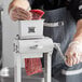 A man using a Backyard Pro meat tenderizer blade set on a piece of meat on a counter in a professional kitchen.