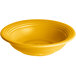 A yellow stoneware bowl with ripples on a white background.