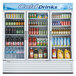 A Turbo Air white three section glass door merchandising refrigerator filled with beverages.