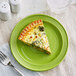A slice of quiche on an Acopa Capri green stoneware plate with a fork.