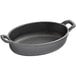 A black oval cast iron casserole dish with handles.