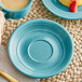 A Caribbean turquoise Acopa Capri saucer with a blue mug and a plate with strawberries and cake.
