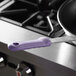 A purple Vollrath silicone pan handle sleeve on a frying pan.