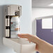 A hand putting a white Rubbermaid Microburst 3000 air freshener refill can into a white dispenser.