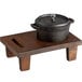 A black Valor cast iron pot on a rustic wooden stand.