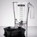 A clear polycarbonate container with a handle and black lid on a Hamilton Beach blender.