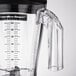 A close-up of a Hamilton Beach polycarbonate blender jar with a measuring cup lid.