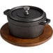 A black Valor cast iron pot on a Rustic Chestnut finish Rubberwood underliner.