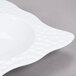 A white square melamine bowl with a pattern on it.