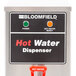 A Bloomfield hot water dispenser on a counter with a red handle.