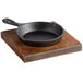 A Valor pre-seasoned cast iron skillet on a rustic wooden tray.