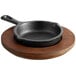 A Valor 3 1/2" pre-seasoned cast iron skillet on a rustic chestnut wood plate.