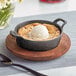 A Valor pre-seasoned mini cast iron bowl with a scoop of ice cream on a table.