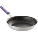A close-up of a Vollrath Wear-Ever 10" non-stick frying pan with a purple handle.