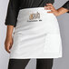 A person wearing a white Choice half bistro apron with a logo on the front.