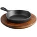 A black cast iron Valor mini skillet on a rustic wooden plate.