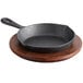 A Valor pre-seasoned cast iron skillet in a Rustic Chestnut finish on a wooden plate.