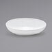 A Front of the House white oval slanted porcelain bowl on a gray background.