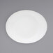 A white oval porcelain platter on a gray surface.