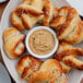 A plate of pretzels with a bowl of Pilsudski Polish Style Horseradish Mustard.