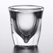 A close up of a clear Anchor Hocking shot glass with a curved bottom.