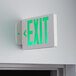 A white sign with green lit up letters that reads "EXIT"