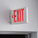 A Lavex red LED exit sign mounted on a wall.