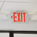 A Lavex Slim red LED exit sign hanging from the ceiling.