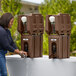 A woman using a Cambro brown portable handwash station to wash her hands