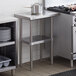 A Regency stainless steel work table with an undershelf in a kitchen.