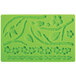 A green silicone Wilton mold with flowers, leaves, a bird, and a worm.