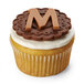 A cupcake with a letter m on top.