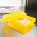 A yellow Vollrath Traex food storage container with a raised lid and food inside.