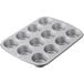A silver Wilton muffin pan with 12 cupcake cups.