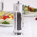 A Chef Specialties customizable gem acrylic pepper mill with black peppercorns inside.