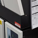 A printer with a white rectangular Avery PermaTrack label on a paper.