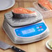 An Avaweigh digital portion scale with a piece of salmon on it.