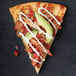 A slice of Rich's pizza with chicken and avocado.