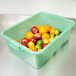 A Vollrath Traex green food storage box filled with fruit.