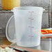A translucent plastic Cambro measuring cup with red writing.