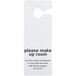 A white Novo Essentials hotel door sign with black text reading "Please Make Up Room" in a white room.