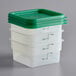 A stack of plastic containers with green lids.