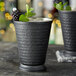 Two Acopa hammered matte black metal mint julep cups with blackberries and ice.