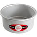 A silver round cake pan with a red and white label.