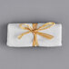 A white shoe mitt wrapped in a natural ribbon with yellow accents.