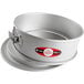 A round silver Fat Daddio's cake pan with a red handle.