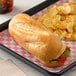 A sandwich on a tray with Amoroso's sliced hoagie roll and potato chips.