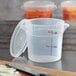 A close up of a Cambro translucent round polypropylene food storage container with a lid.