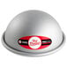 A silver round hemisphere cake mold with a red and white sticker.